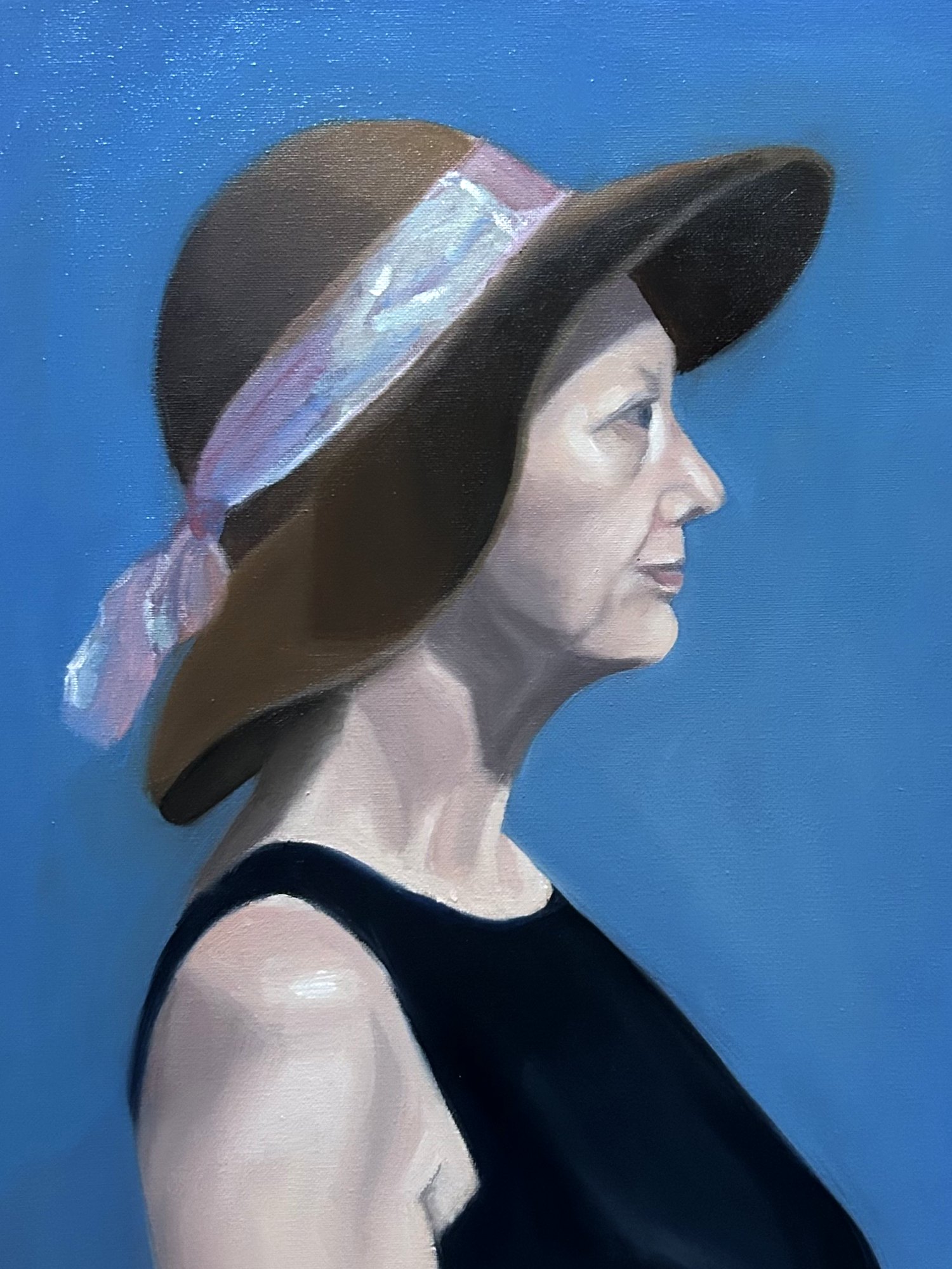 Oil painting of a woman in profile wearing a brown wide-brimmed hat with a lavender ribbon, against blue