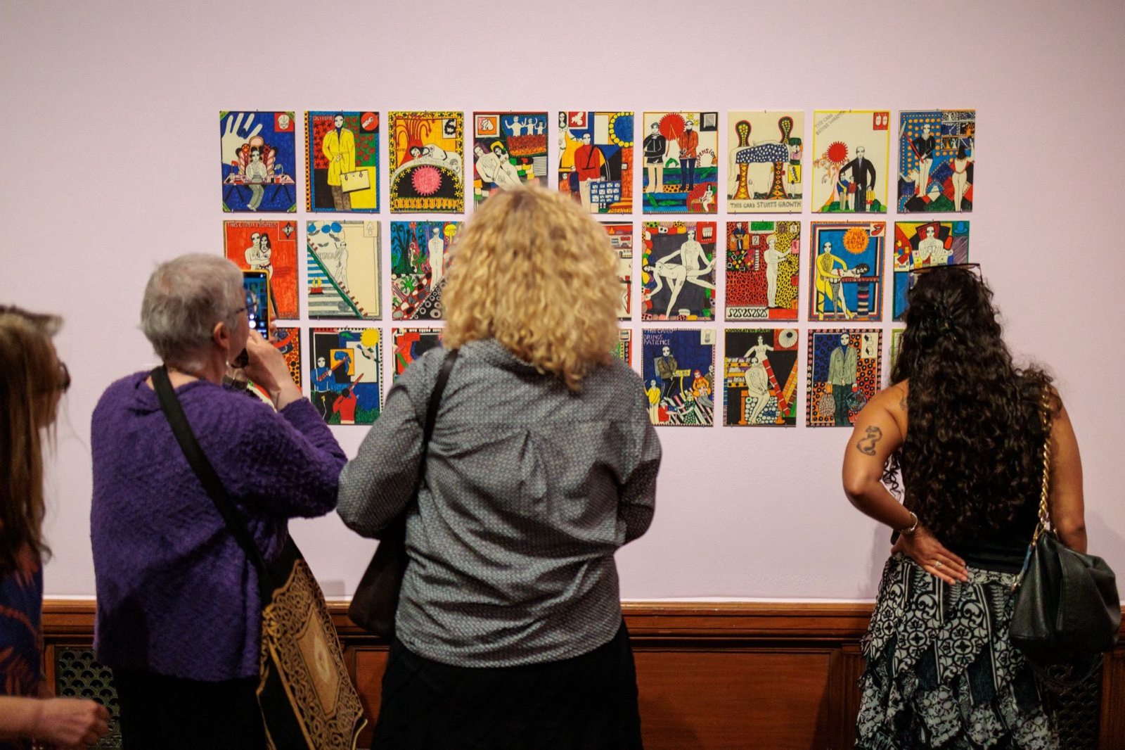 Guests looking at a wall of illustrated tarot cards